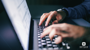 A pair of Caucasian toned hands type on a laptop keyboard