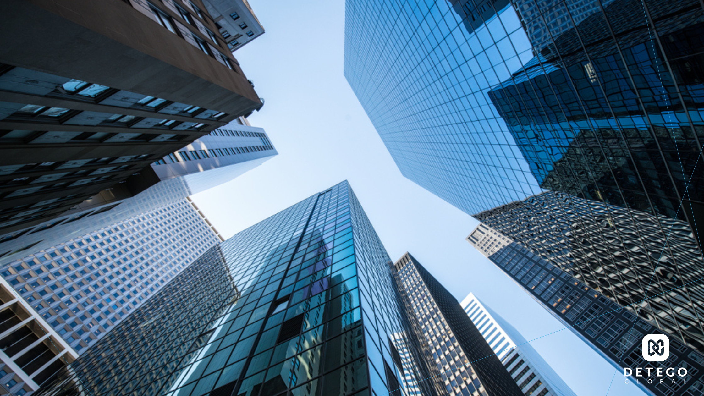 Glass skyscrapers tower into the sky as the camera looks upward