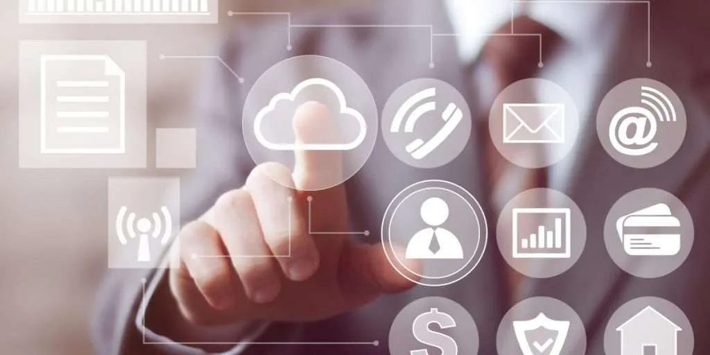 A white man in a business suit touches his finger to a cloud icon on a clear screen