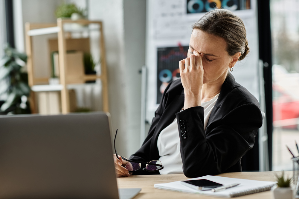 woman at laptop looking stressed
